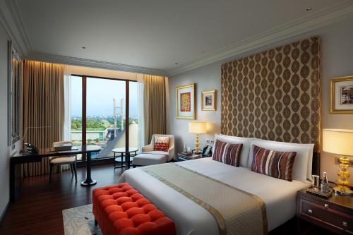 a hotel room with a bed and a large window at The Leela Gandhinagar in Gandhinagar