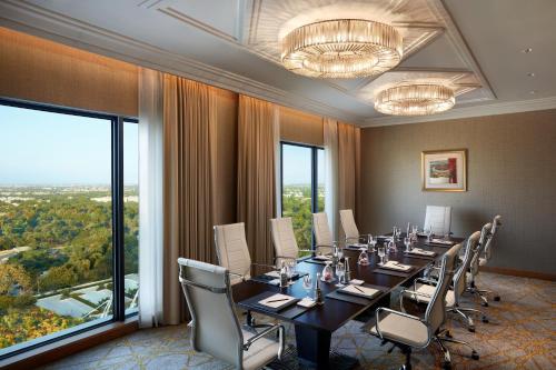 a conference room with a long table and chairs at The Leela Gandhinagar in Gandhinagar