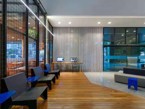 a lobby with couches and chairs and a table at Mercure Belo Horizonte Vila da Serra in Belo Horizonte