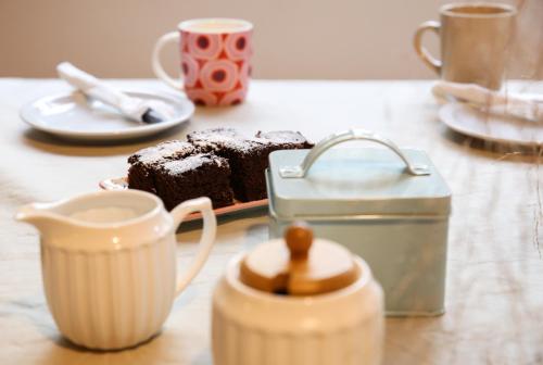 a table with a chocolate cake and a tea pot at La Justina Hostel in San Carlos de Bariloche