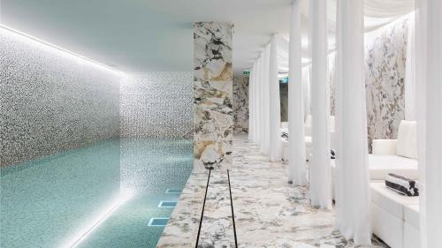 a bathroom with a turquoise swimming pool at Wine & Books Porto Hotel in Porto
