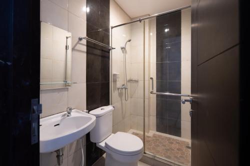 uma casa de banho com um chuveiro, um WC e um lavatório. em Cove Sky City Home em Bandung