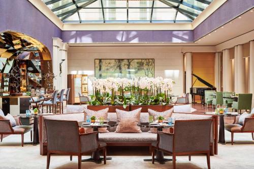 a lobby with a table and chairs and flowers at Park Hyatt Paris - Vendôme in Paris