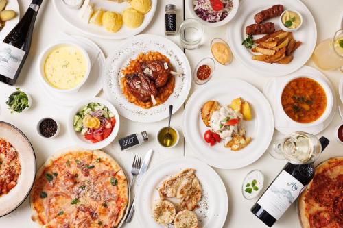 una mesa blanca con platos de comida. en Pensiunea RYN en Sebeş
