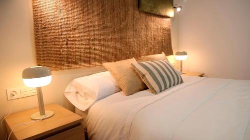 ein Schlafzimmer mit einem Bett mit zwei Lampen und einem Fenster in der Unterkunft HOTEL LOS ALAMOS BOUTIQUE in Plasencia