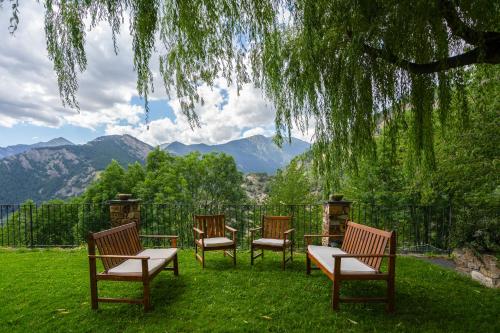 four chairs and a table with a view of mountains at Abba Ordino Babot Hotel in Ordino