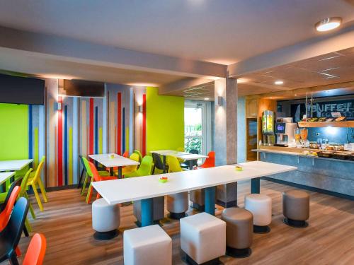 a restaurant with tables and chairs and a kitchen at ibis budget Coutances in Coutances