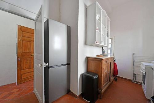 La cuisine est équipée d'un réfrigérateur et d'une armoire en bois. dans l'établissement Les Brunes - Wi-Fi - CENTRE VILLE - Proche Théatres, à Avignon