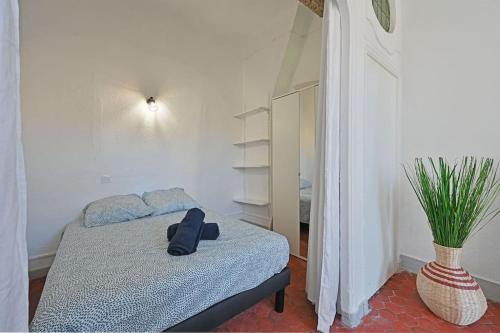 une chambre avec un lit avec un chapeau dessus dans l'établissement Les Brunes - Wi-Fi - CENTRE VILLE - Proche Théatres, à Avignon