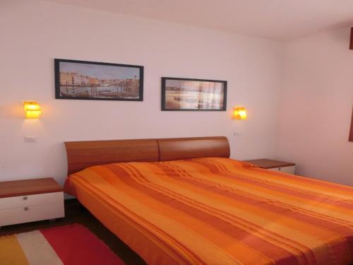 1 dormitorio con 1 cama y 2 cuadros en la pared en Modern flat in a fantastic residence with pool, en Bibione