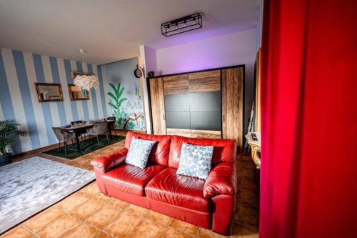 un sofá rojo en una sala de estar con mesa en Art Apartment Ticino en Vacallo