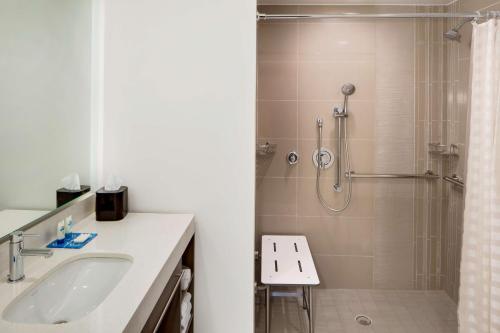 a bathroom with a shower and a sink and a toilet at Hyatt House across from Universal Orlando Resort in Orlando