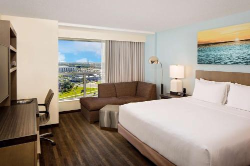 Habitación de hotel con cama, sofá y ventana en Hyatt House across from Universal Orlando Resort en Orlando
