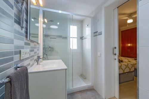 a bathroom with a sink and a glass shower at Riviera Park 2b, central 2 bed in Puerto del Carmen