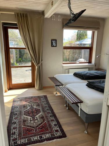 een slaapkamer met 2 bedden, een tapijt en een raam bij Hus og have i Herning, 100 kvm ialt in Herning