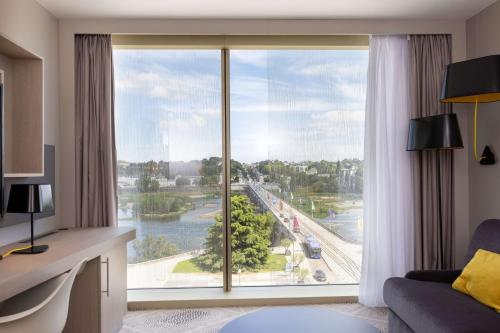 a room with a large window with a view of a river at Hilton Garden Inn Tours Centre, France in Tours