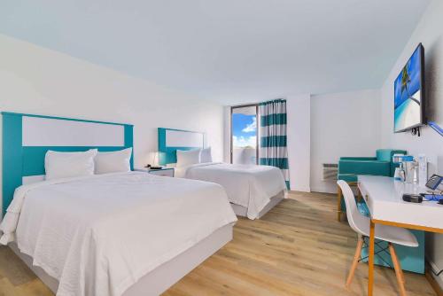 Pokój hotelowy z 2 łóżkami i biurkiem w obiekcie Chateau Mar Golf Resort, Trademark Collection by Wyndham w mieście Lauderhill