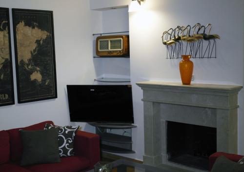 een woonkamer met een open haard en een televisie bij Ribo Apartments in Angri