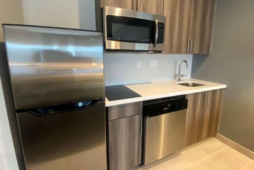 a kitchen with a stainless steel refrigerator and a sink at La Quinta Inn & Suites by Wyndham Centralia in Centralia