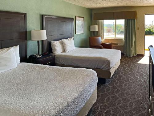 ein Hotelzimmer mit 2 Betten und einem Stuhl in der Unterkunft Quality Inn in Clinton