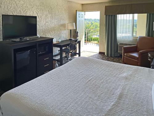 a hotel room with a bed and a flat screen tv at Quality Inn Clinton North in Clinton