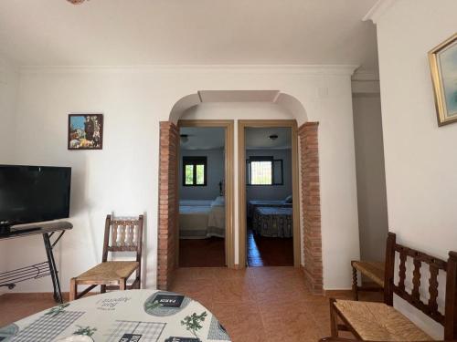 a living room with a television and a bedroom at Alojamiento rural Huerta Mandre in Cuevas del Becerro