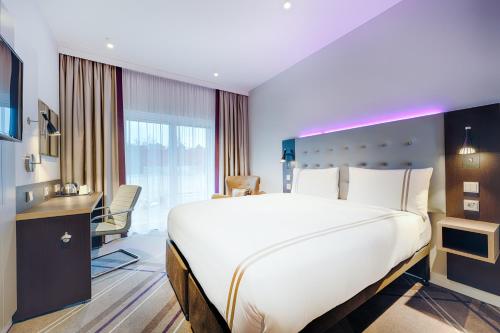 a hotel room with a large bed and a desk at Premier Inn Frankfurt City Europaviertel in Frankfurt/Main