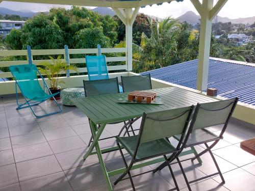 un tavolo verde e sedie su un patio di Kaz Serenity a Sainte-Rose