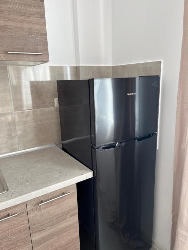 a black refrigerator in a kitchen next to a counter at Pollux Residence Militari ap 84 in Dudu