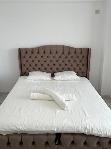 a bed with white sheets and pillows on it at Pollux Residence Militari ap 84 in Dudu