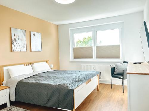 1 dormitorio con cama, escritorio y ventana en MELLoWY: Rückzugsort Cölpin 4 Personen, 