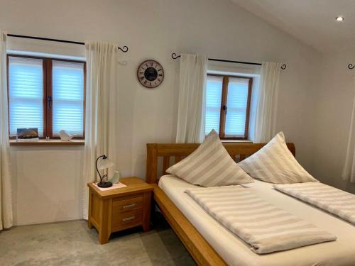 1 dormitorio con 2 camas y reloj en la pared en Chalet Hochgern, en Staudach-Egerndach