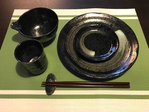 a pair of chopsticks and a plate and two bowls at アンドステイ中野弥生町 in Tokyo