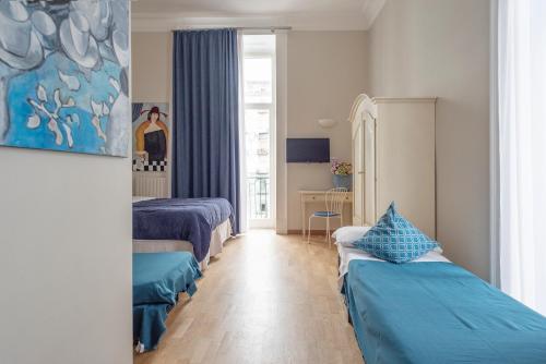 a hotel room with two beds and a window at B&B Donna Adelina in Naples