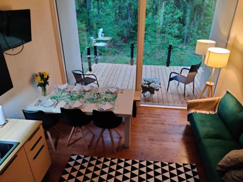 ein Wohnzimmer mit einem Tisch und Blick auf eine Terrasse in der Unterkunft Yksipuinen in Ähtäri