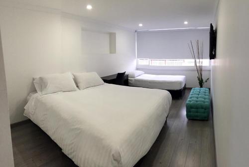 a hotel room with two beds and a window at Hotel Metro 26 in Bogotá