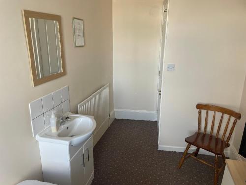 a bathroom with a sink and a chair at The Waterside in Redcar