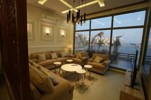 un soggiorno con divani e tavoli e una grande finestra di Ajmkan Resort a Al Khobar