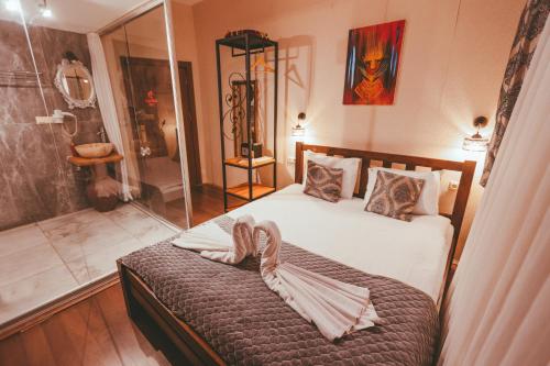 a bedroom with a bed and a glass shower at Pigeon Valley Hotel in Uchisar