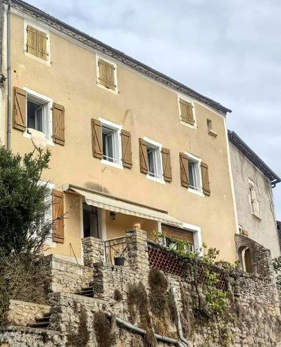 a large building with windows on top of a stone wall at La maison d'Innes in Lamagdelame