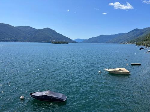 zwei Boote in einem großen Wasserkörper in der Unterkunft Villa Aurora: Porto Ronco in Ronco sopra Ascona