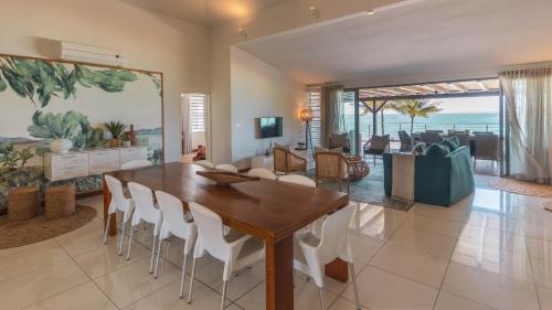 uma sala de jantar e sala de estar com mesa e cadeiras em Paradise Beach by Horizon Holidays em Pointe d'Esny