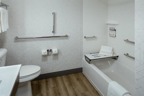 La salle de bains blanche est pourvue de toilettes et d'une baignoire. dans l'établissement Holiday Inn Express Corvallis-On the River, an IHG Hotel, à Corvallis