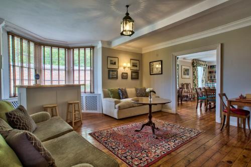 a living room with a couch and a table at Abbey House by Group Retreats in Saffron Walden
