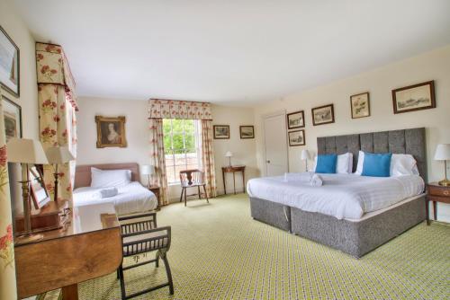 a large bedroom with two beds and a desk at Abbey House by Group Retreats in Saffron Walden