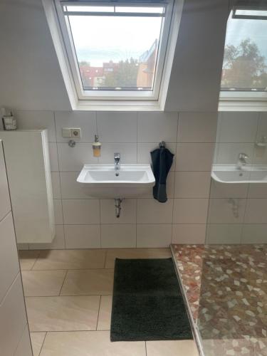 a bathroom with a sink and two windows at An der Bürgeheide in Finsterwalde