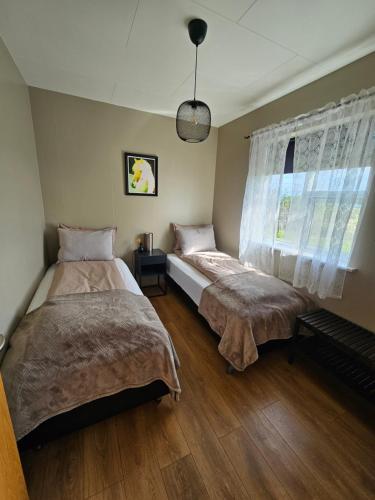 1 dormitorio con 2 camas y ventana en Skeiðvellir Villa, en Hella