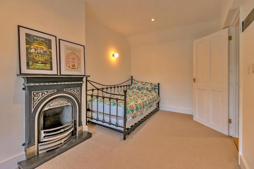 Dormitorio pequeño con cuna y chimenea en Finest Retreats - The Old Coach House en Stony Stratford