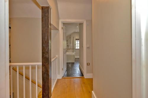 a hallway with a stairway leading to a bathroom at Finest Retreats - The Old Coach House in Stony Stratford