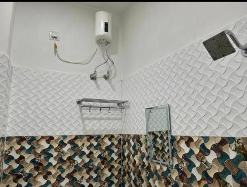 uma casa de banho com uma parede de azulejos e um chuveiro em Lotus Paying Guest house em Varanasi